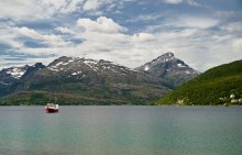 A typical Norwegian fjord landscape with mountains and the fishing schooner. / ***