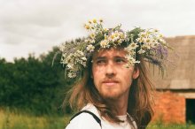 A young man with a wreath of wild flowers / ***