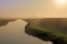 A fisherman in the morning. / A fisherman in the morning light.