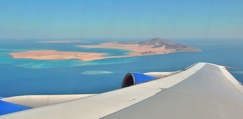 Under the wing of an airplane / ***